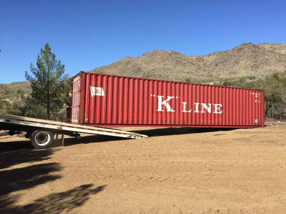 A red kline shipping container is sitting on a trailer