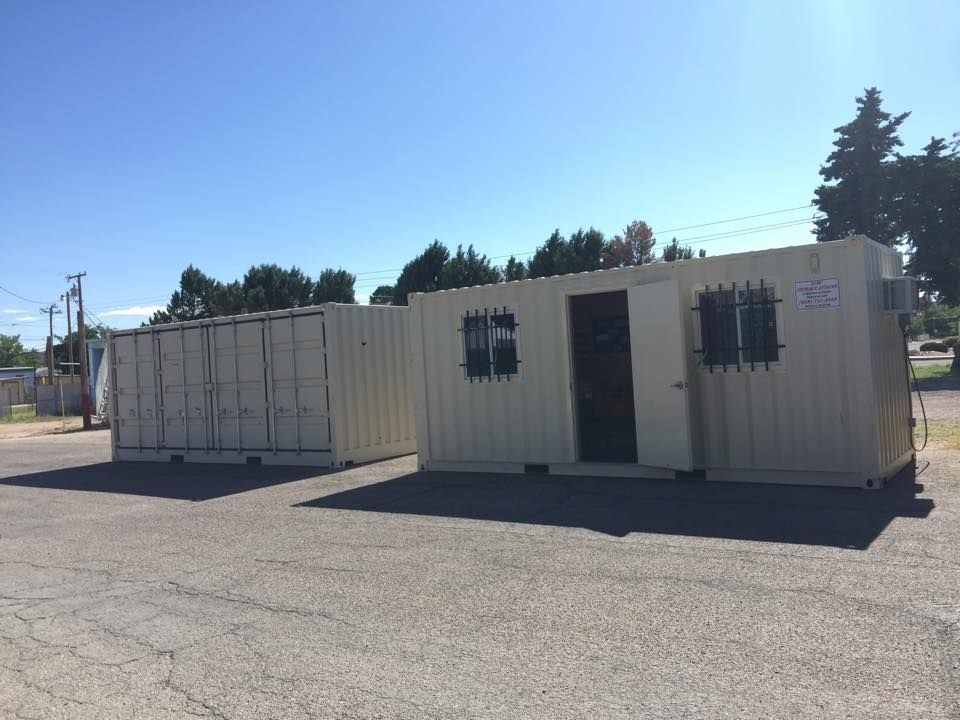 Two shipping containers are parked next to each other in a parking lot.