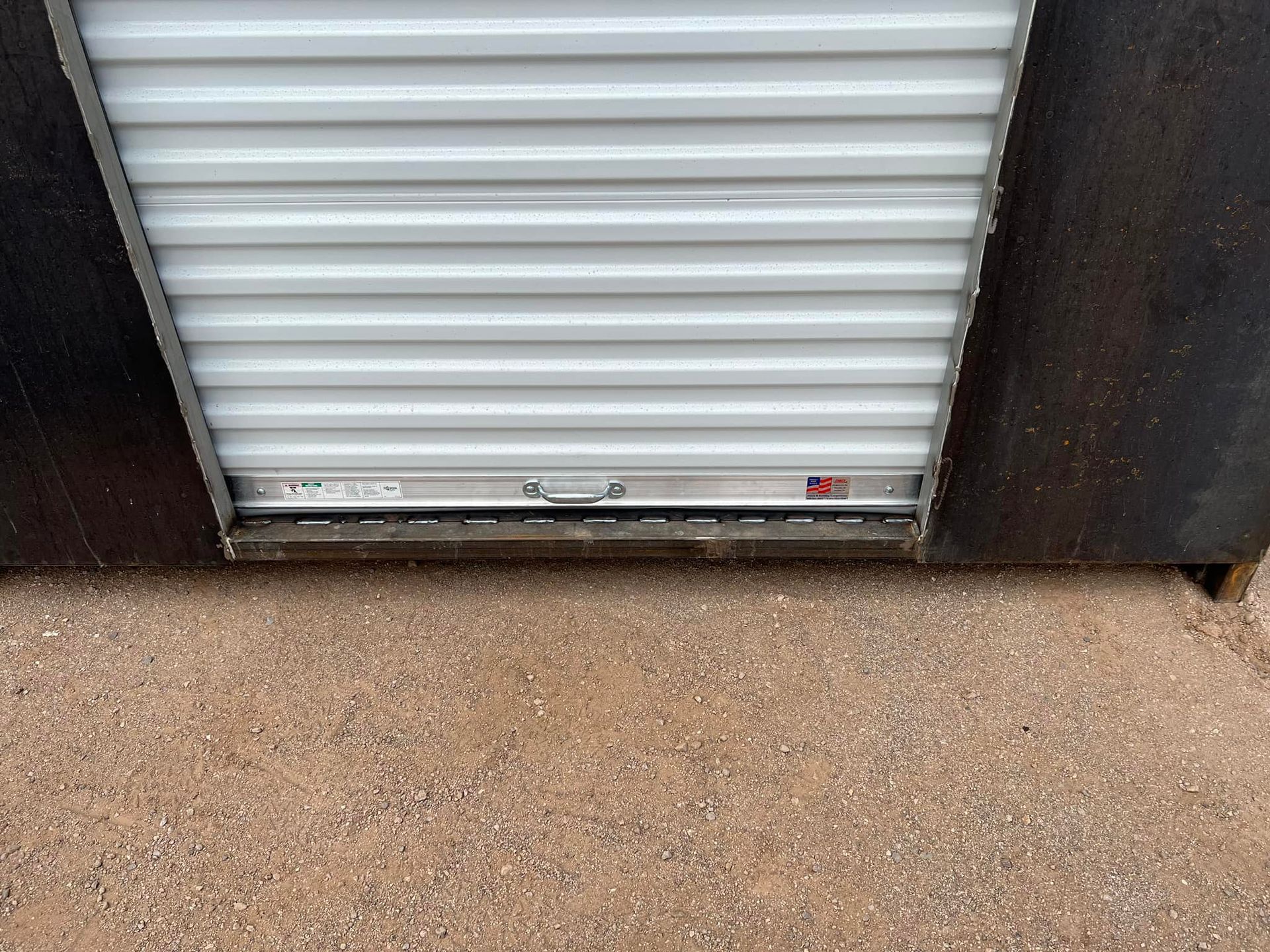 A close up of a white garage door on a building.