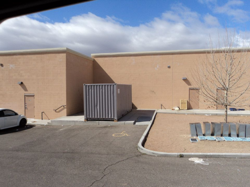 A white car is parked in front of a building