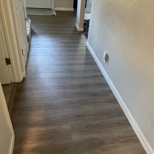 A hallway with hardwood floors and white trim in a house.