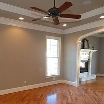 A living room with hardwood floors and a ceiling fan.