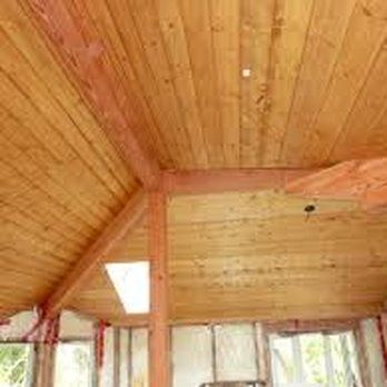 A room with a wooden ceiling and a lot of windows.