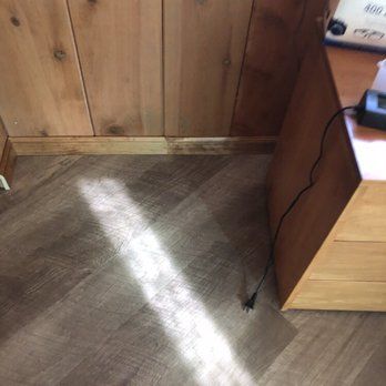 A shadow of a person is cast on a wooden floor in a room.