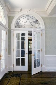 A room with french doors and a stained glass window.