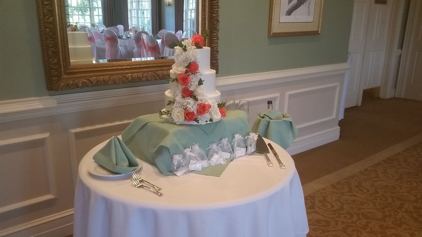 A wedding cake is sitting on top of a table in a room.