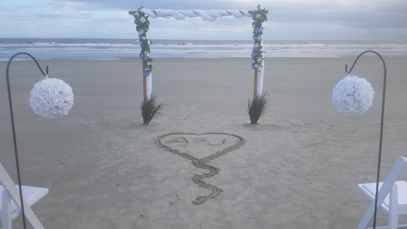 There is a heart drawn in the sand on the beach.