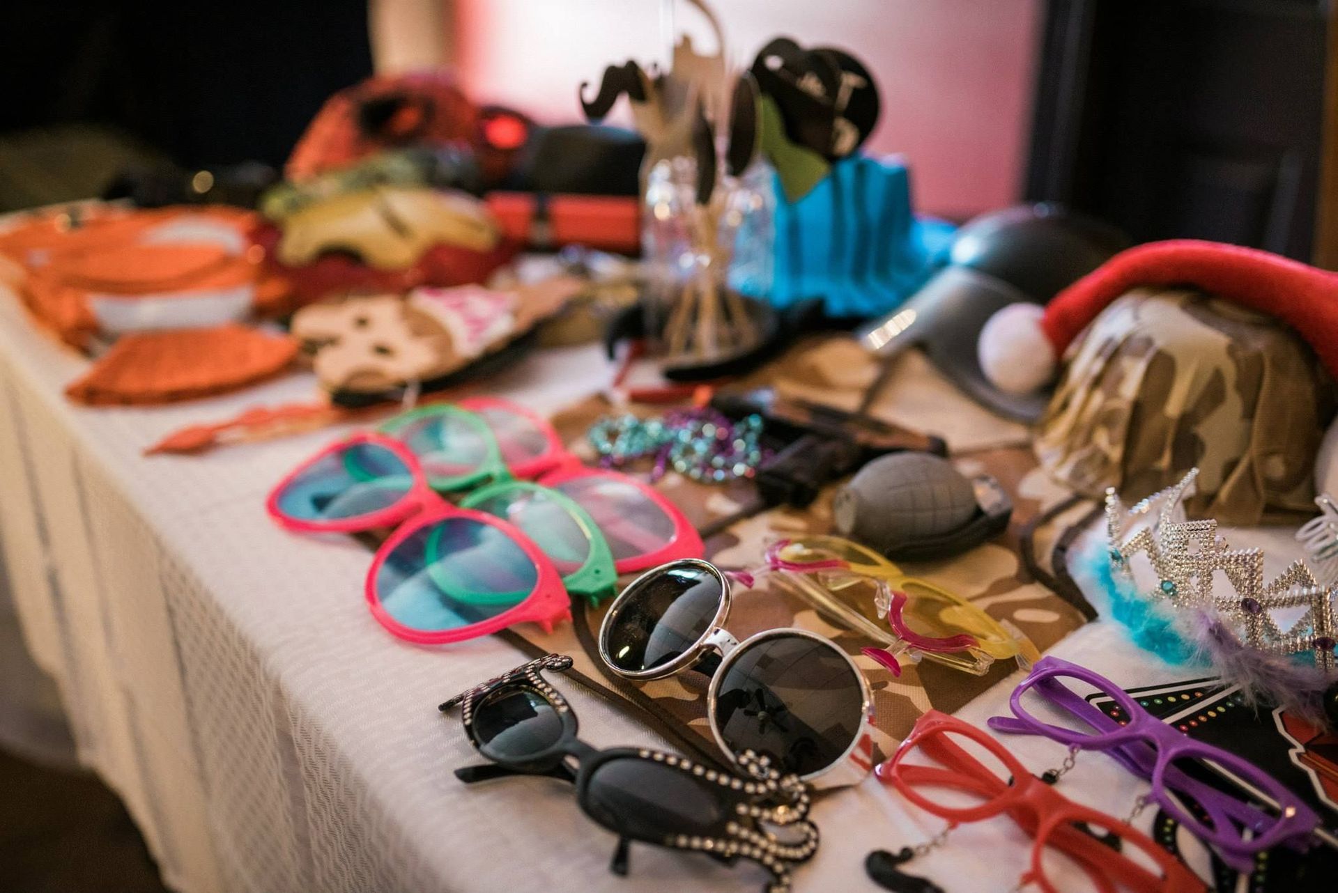 A table topped with sunglasses , hats , and other props.