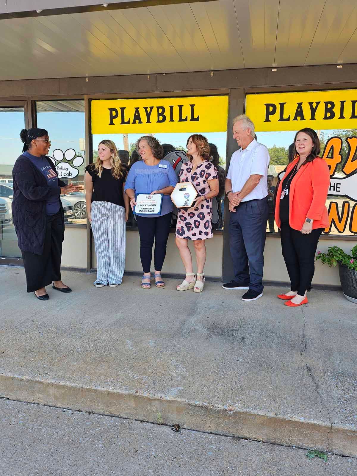 A group of people standing outside a building with 