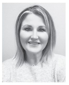 Woman with blonde highlights smiling, wearing a light-colored sweater.