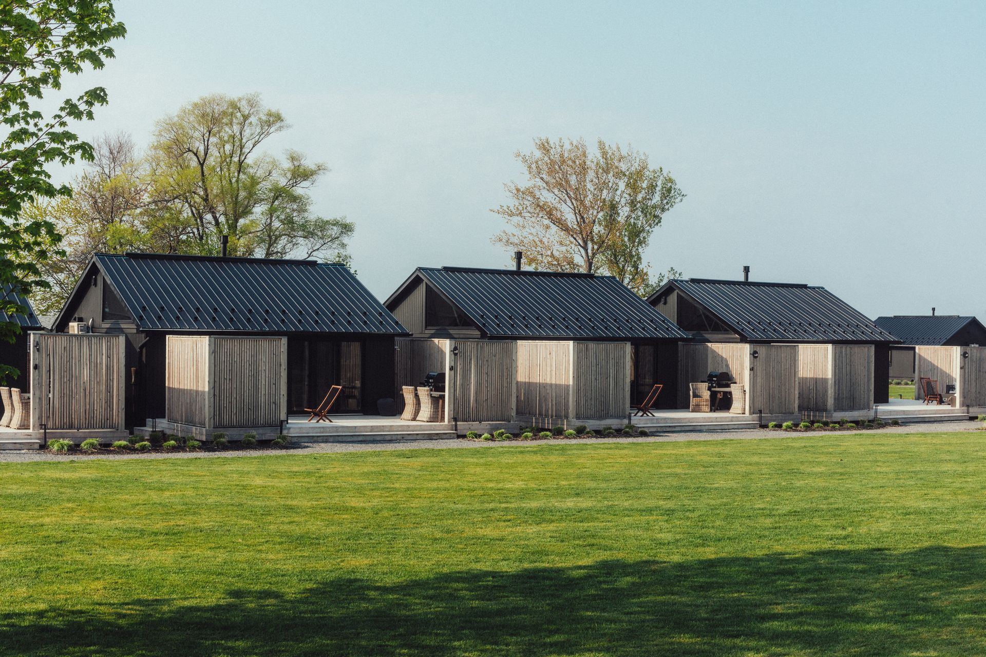 Rooftop pool and jacuzzi at night, lit by underwater lights, fire pit, and wall lighting.