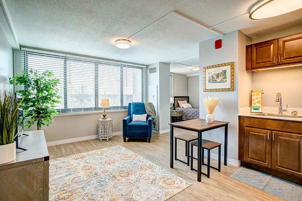 A living room with a table and chairs and a kitchen.