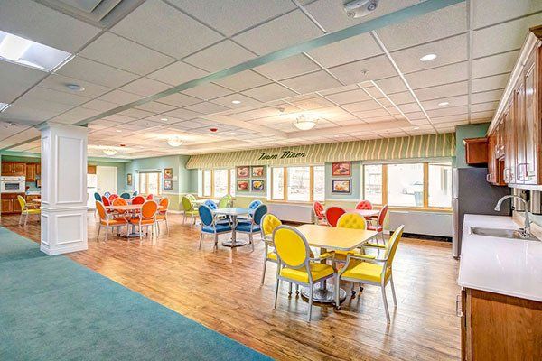 There are many tables and chairs in this large room.