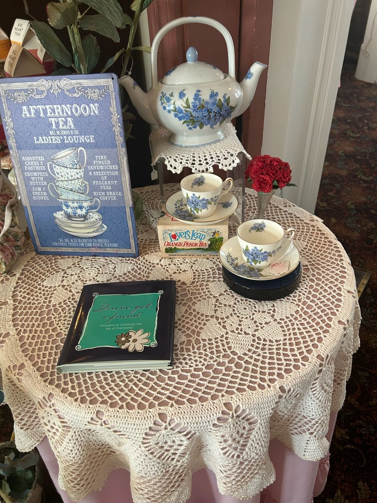 A person is holding a cup of coffee on a saucer on a tray.