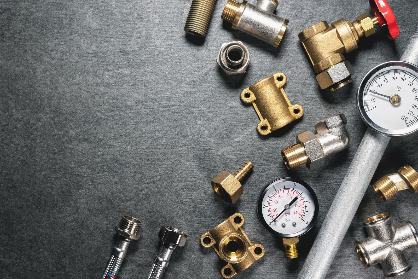 There are many different types of plumbing parts on the table.