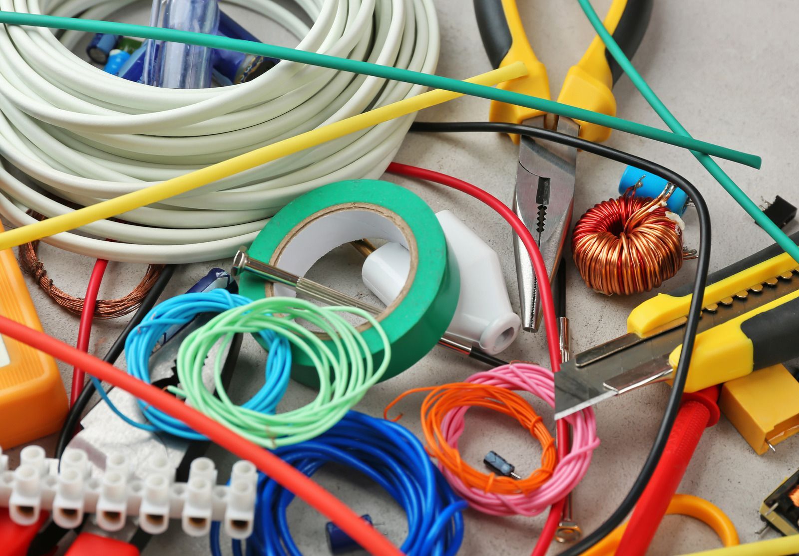 A bunch of different colored wires and tools on a table