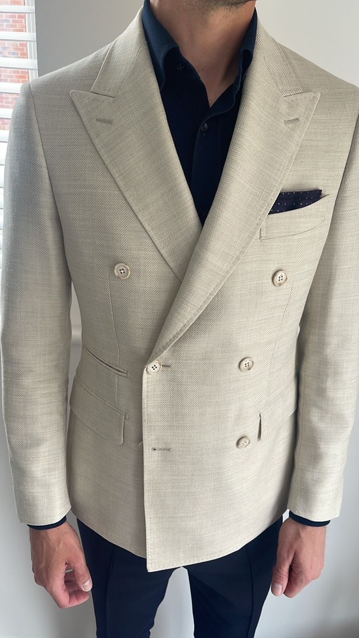 A man wearing a white double breasted suit jacket