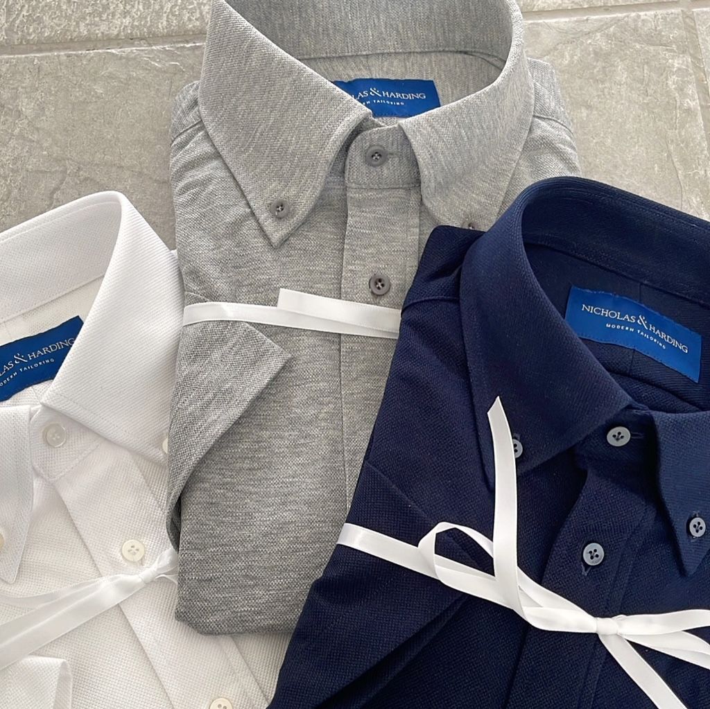 Three men 's shirts are tied together with a white ribbon