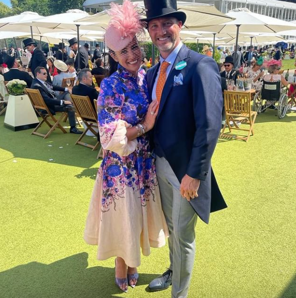 A man and a woman are posing for a picture in a field