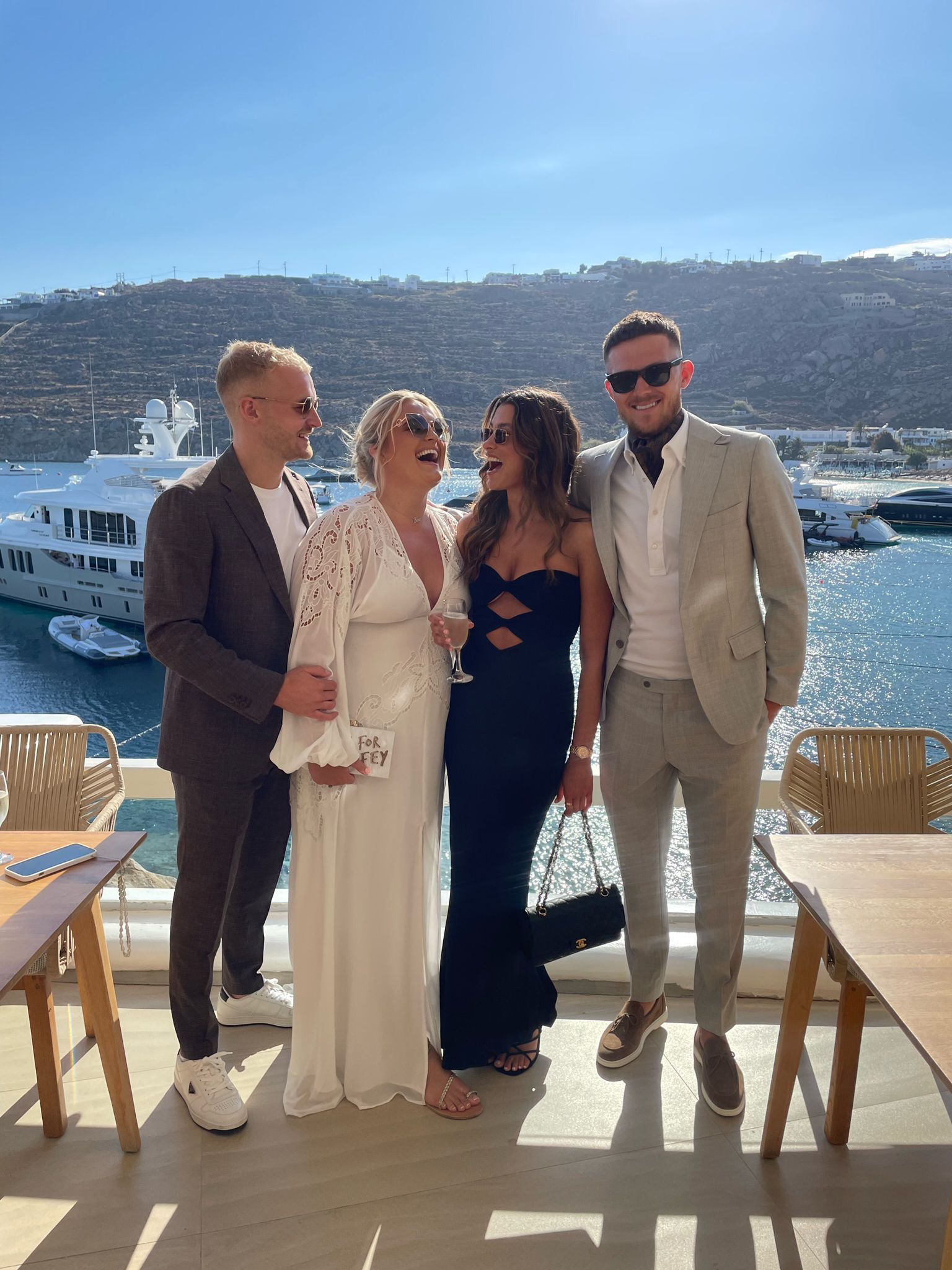 A group of people standing next to each other on a balcony overlooking the ocean.