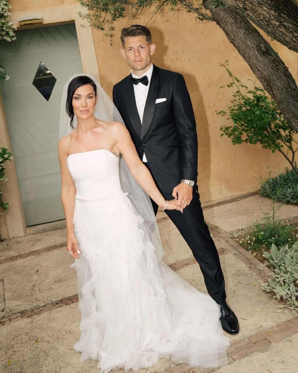 A bride and groom holding hands in front of a building