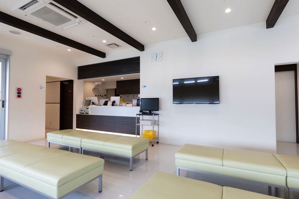 A waiting room with benches and a television on the wall.