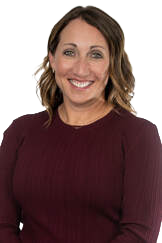 Woman with shoulder-length brown hair smiling, wearing a dark red sweater.