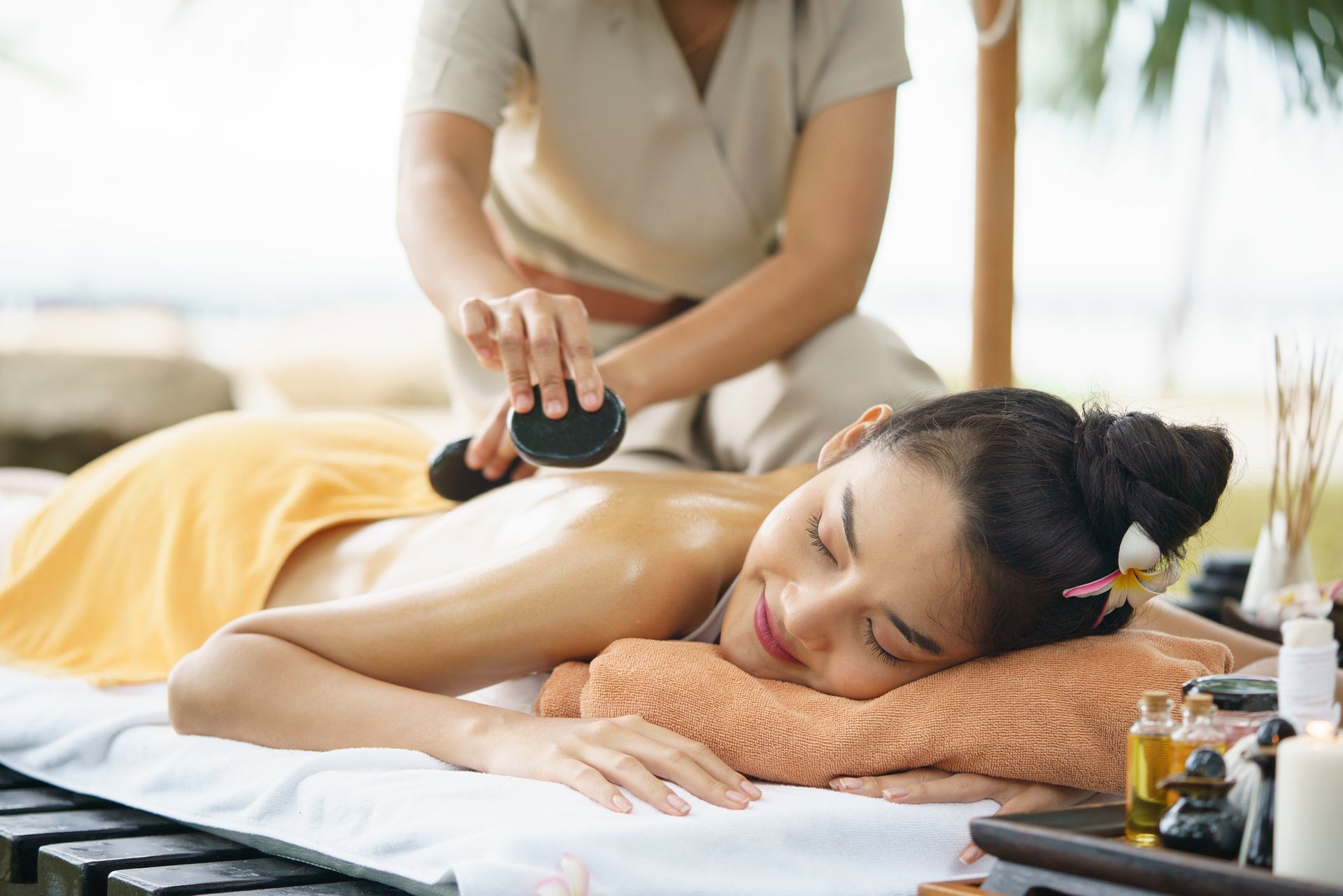 A Woman Is Getting a Massage with Rocks at A Spa - Honolulu, HI - Hawaii Choi Spa