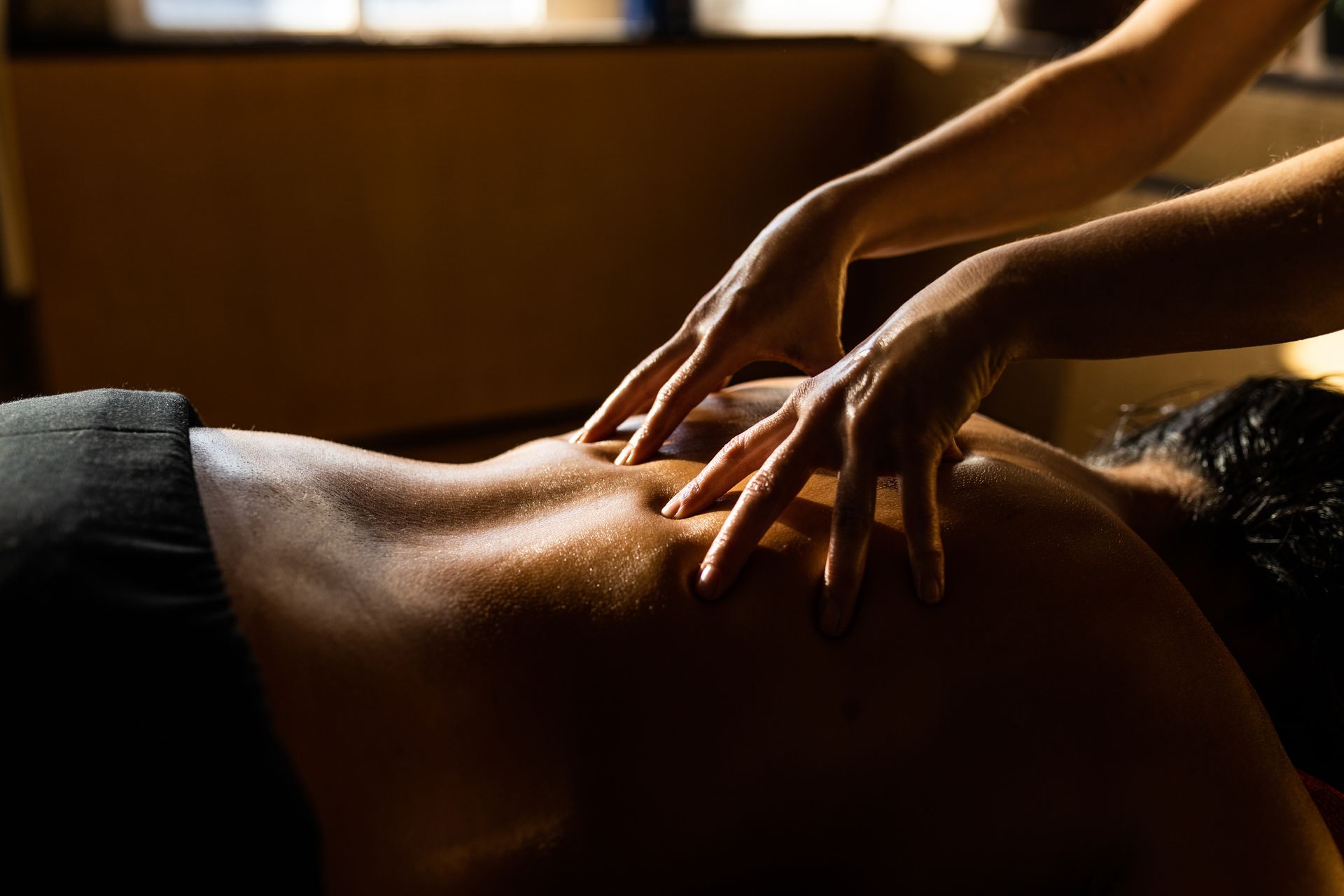 A Woman Is Giving a Man a Massage in A Dark Room - Honolulu, HI - Hawaii Choi Spa
