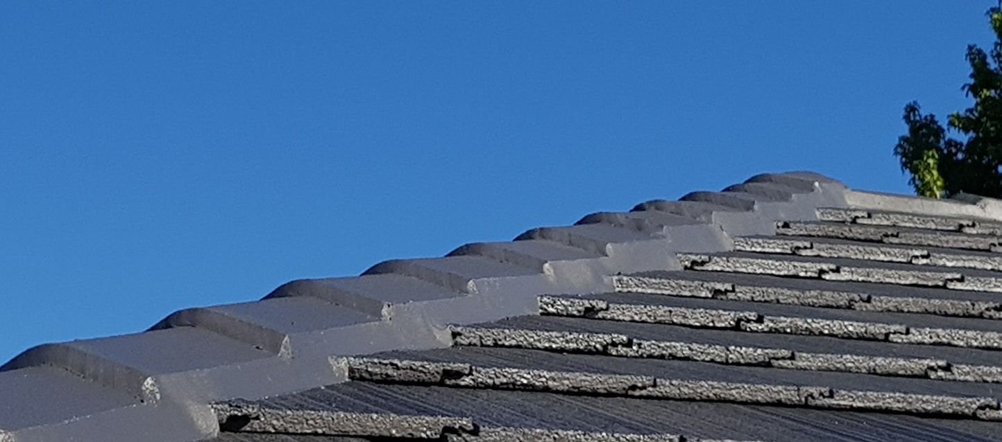 A close up of a roof with a blue sky in the background.