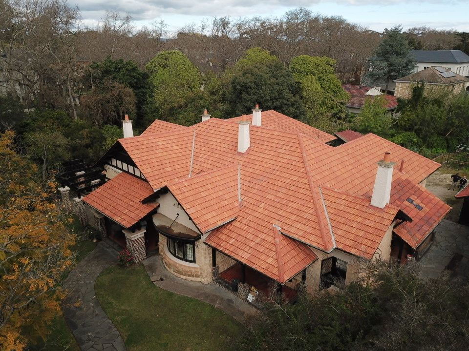A brick building with a red tiled roof and scaffolding in front of it.