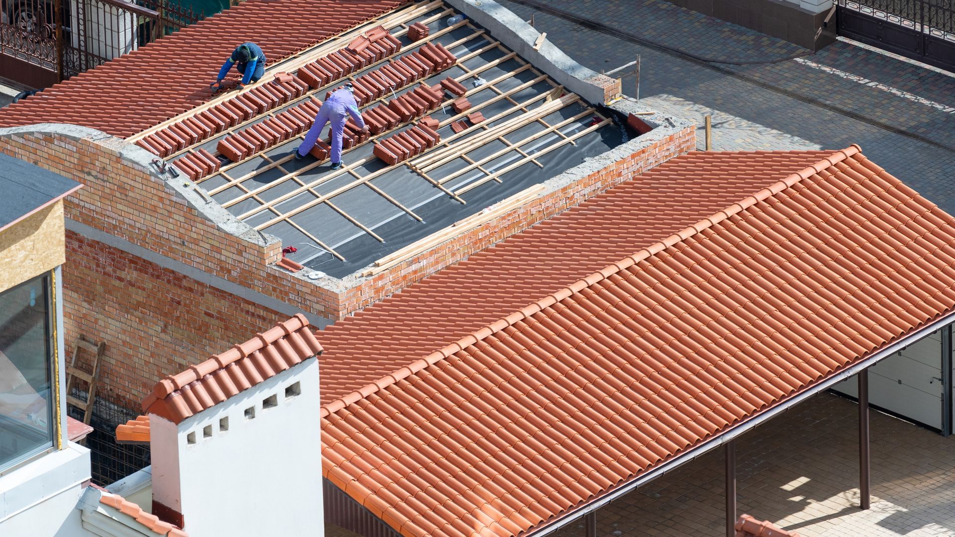 A man is working on the roof of a building