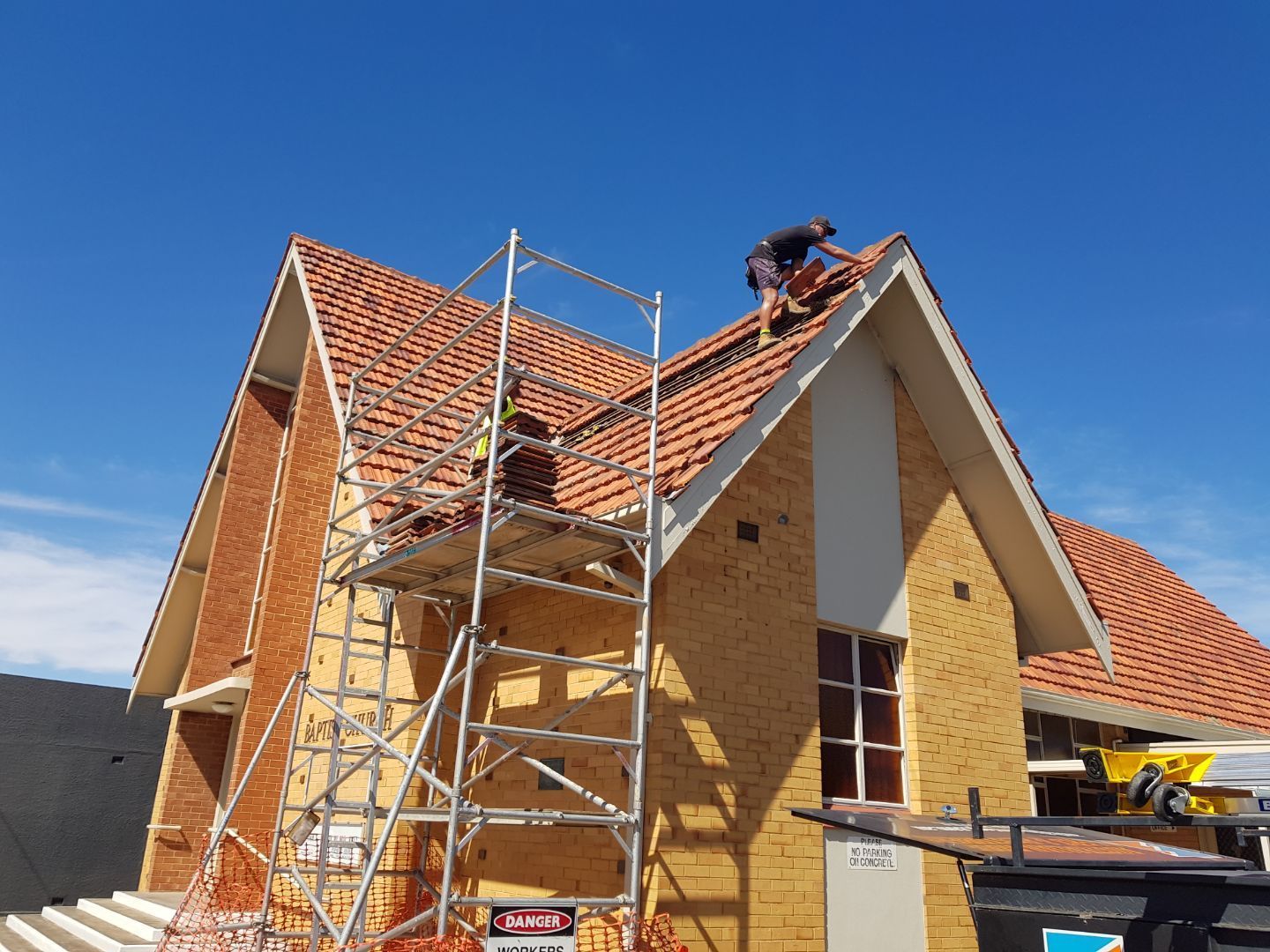 A man is working on the roof of a house.