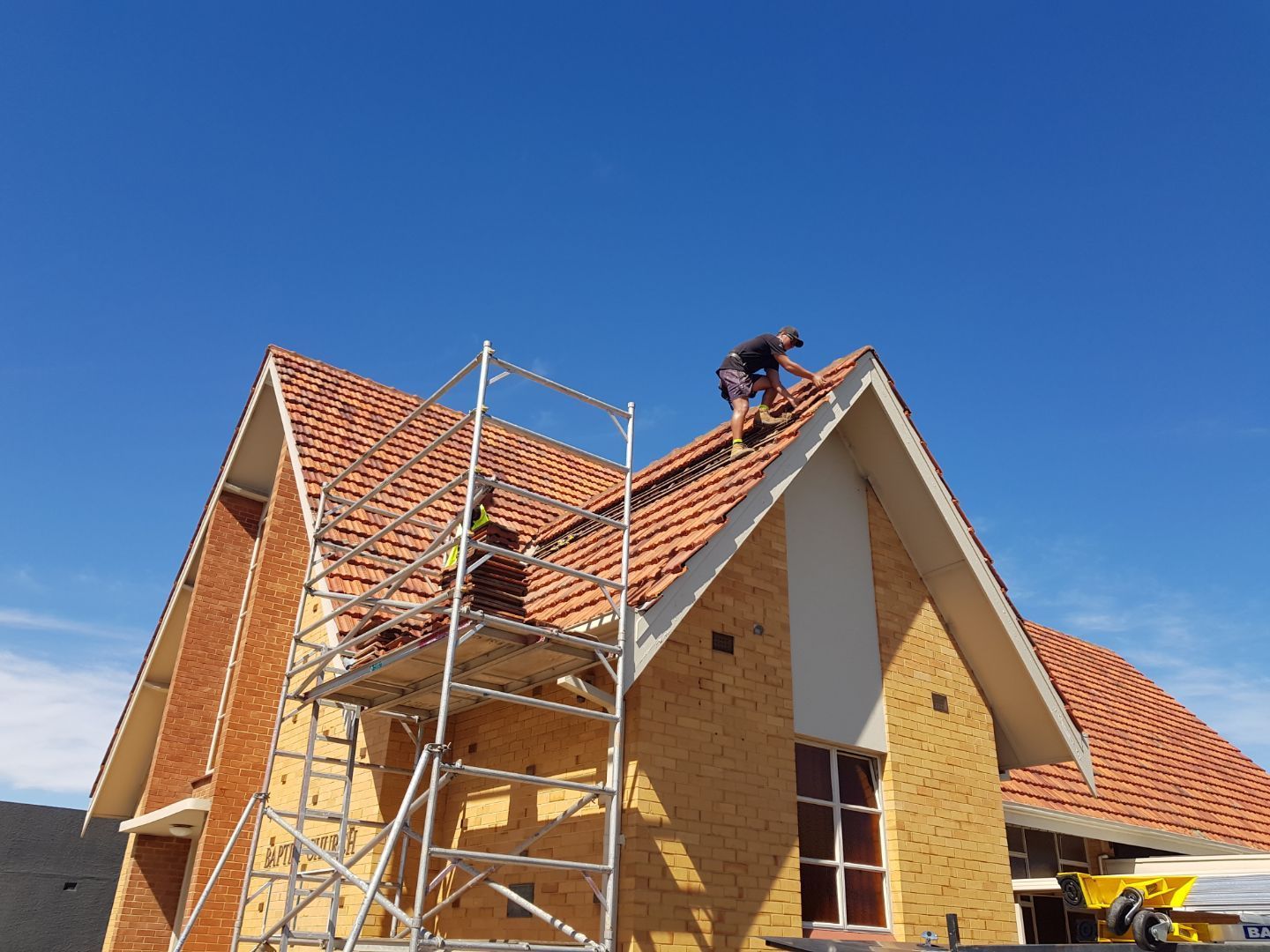 A man is working on the roof of a house
