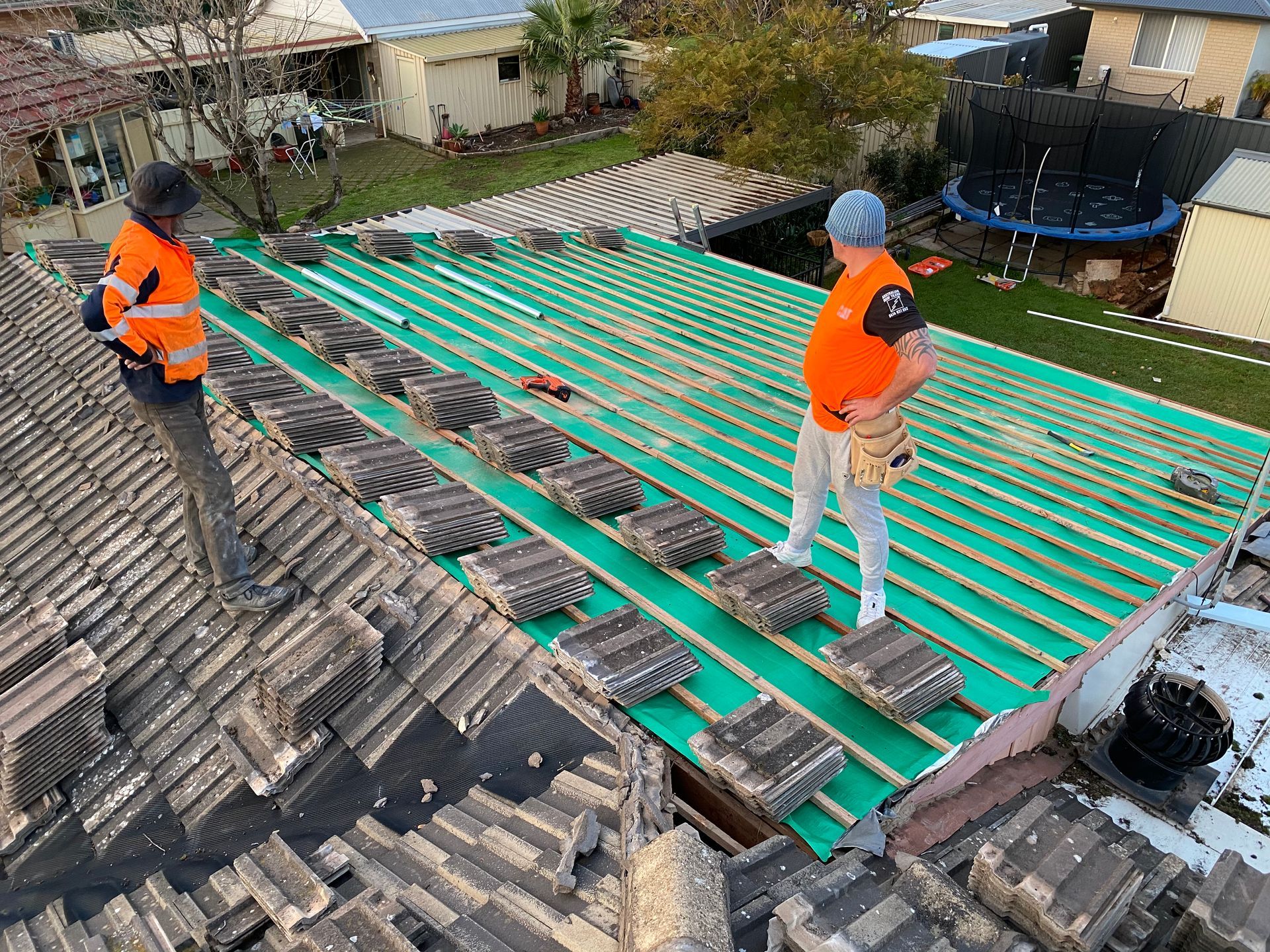 Two men are standing on top of a roof.