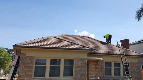 A man is working on the roof of a house.