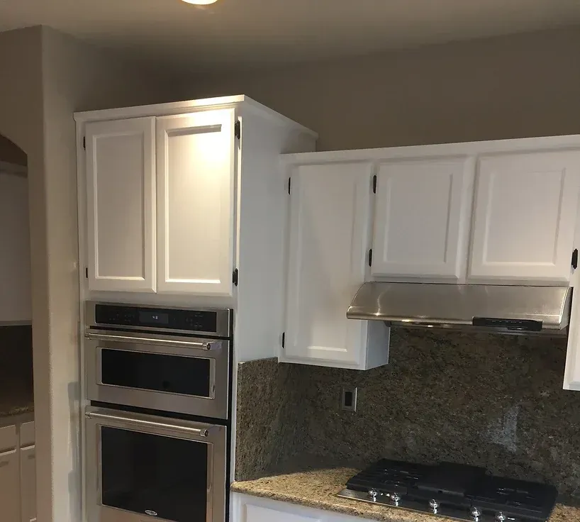 A kitchen with stainless steel appliances and white cabinets