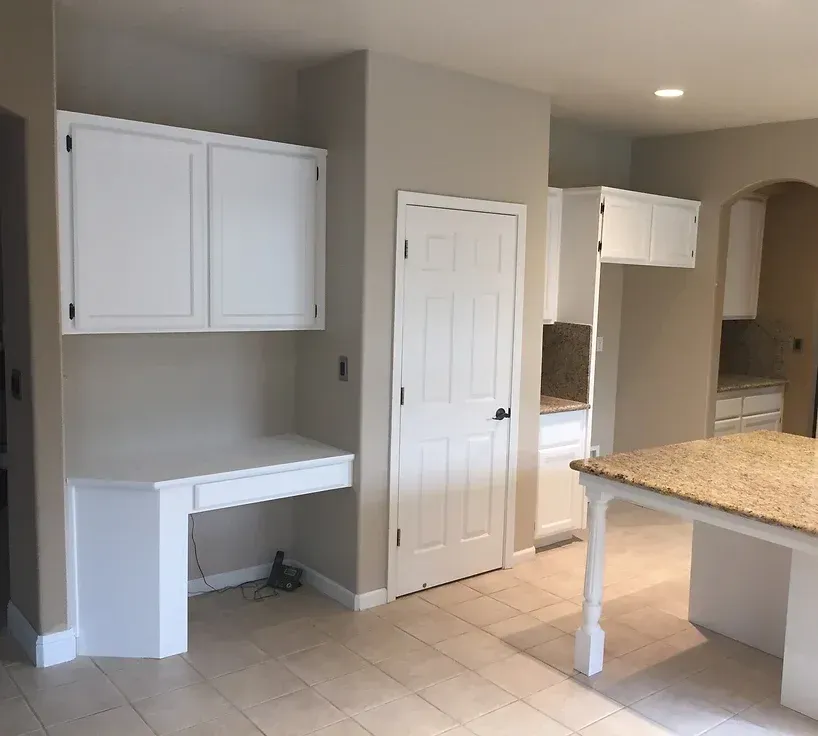 A kitchen with white cabinets and a granite counter top
