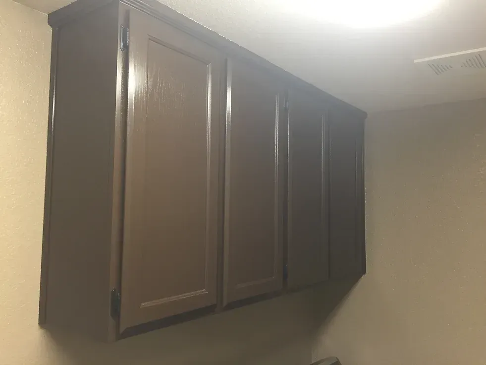 A laundry room with a lot of cabinets hanging from the ceiling.