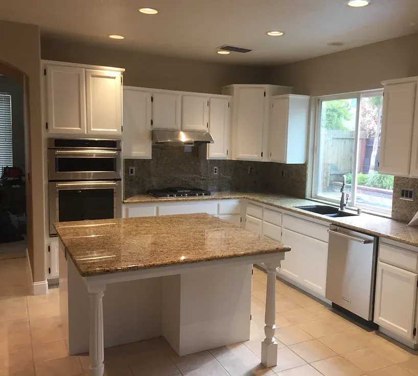 A kitchen with white cabinets and granite counter tops