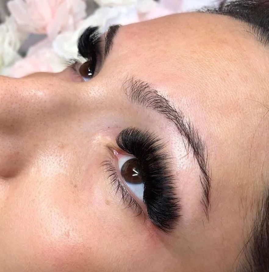 A close up of a woman 's eye with long eyelashes.