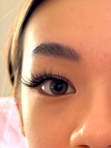 A close up of a woman 's eye with long eyelashes.