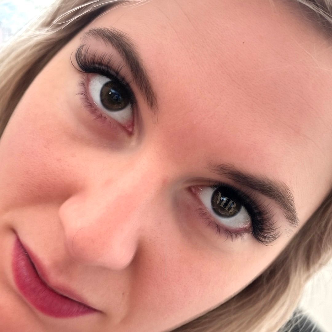 A close up of a woman 's face with her eyes looking at the camera