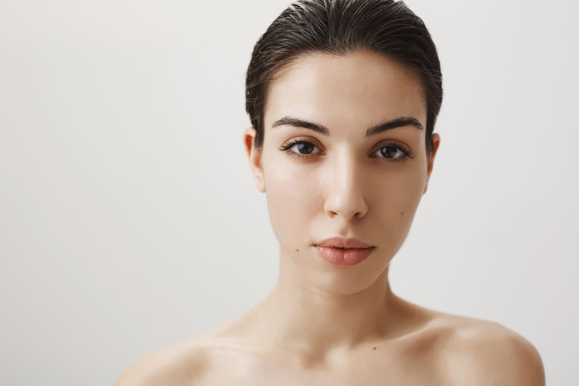 A close up of a woman 's face with a white background.