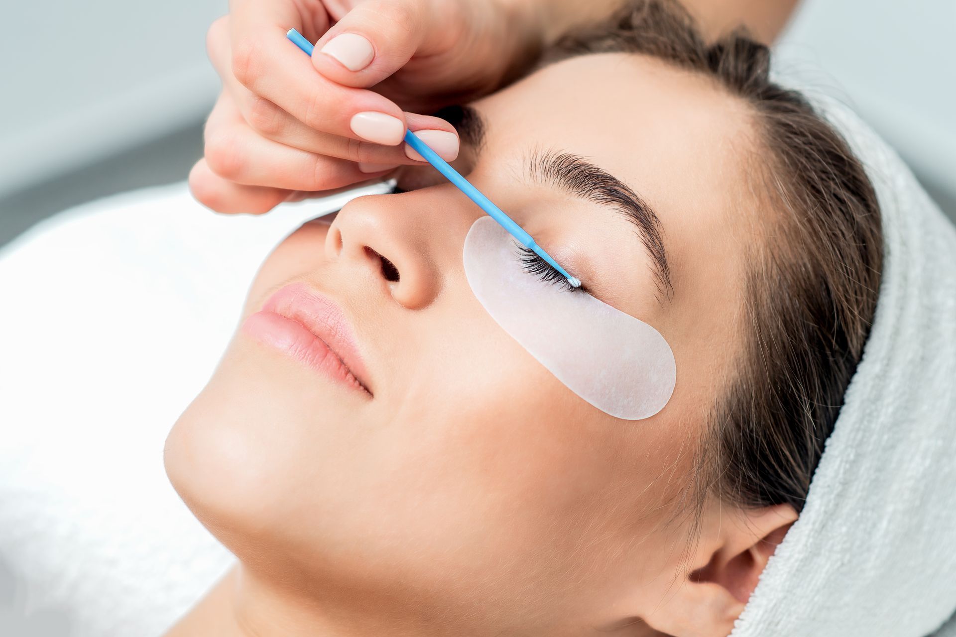 A woman is getting her eyelashes done at a beauty salon.