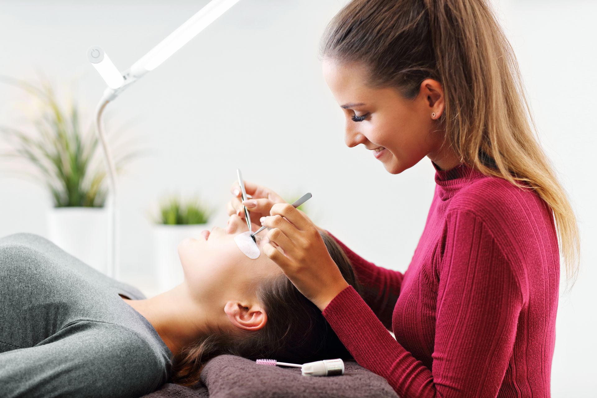 A woman is getting her eyelashes done at a beauty salon.