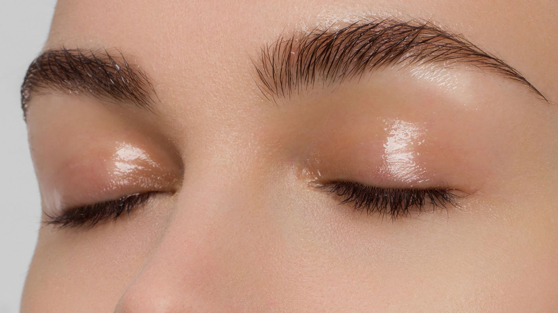 A close up of a woman 's face with her eyes closed.