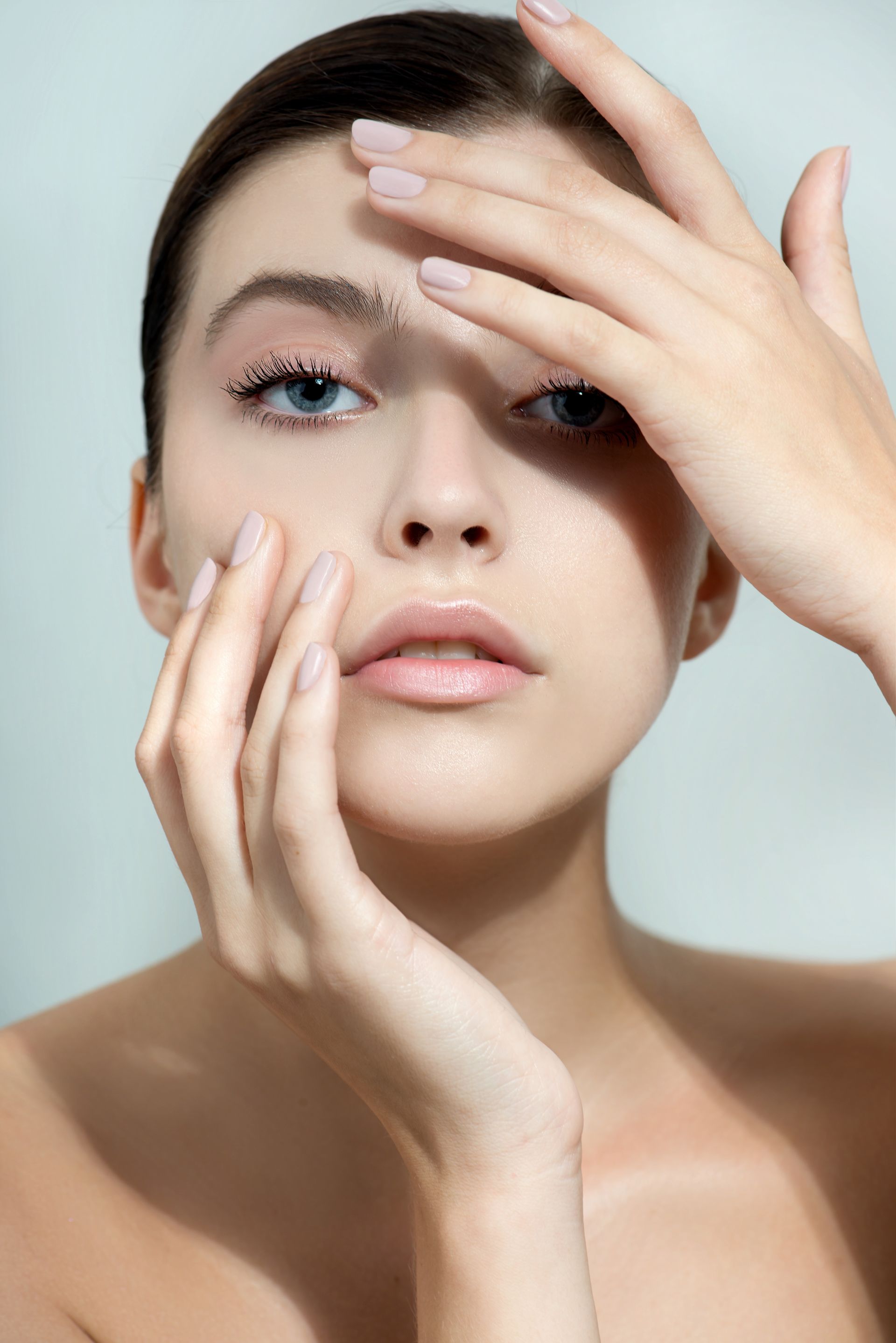 A woman is covering her face with her hands.