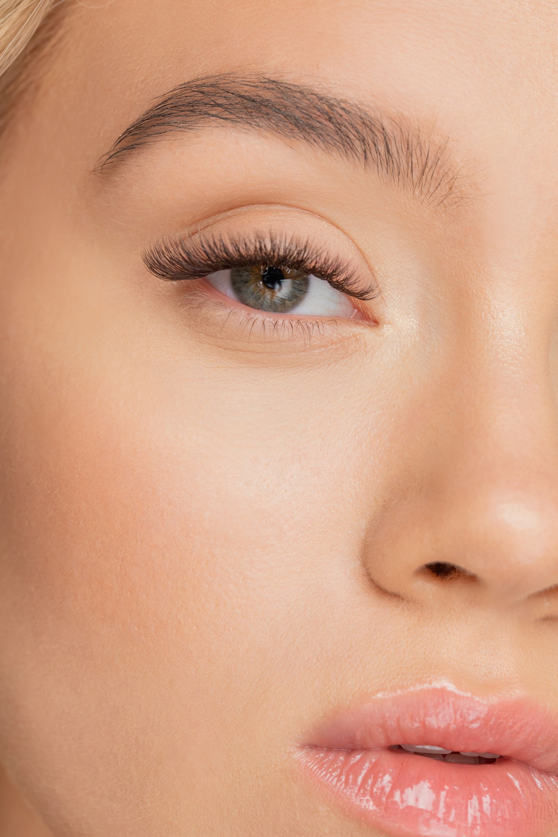 A close up of a woman 's face with long eyelashes.