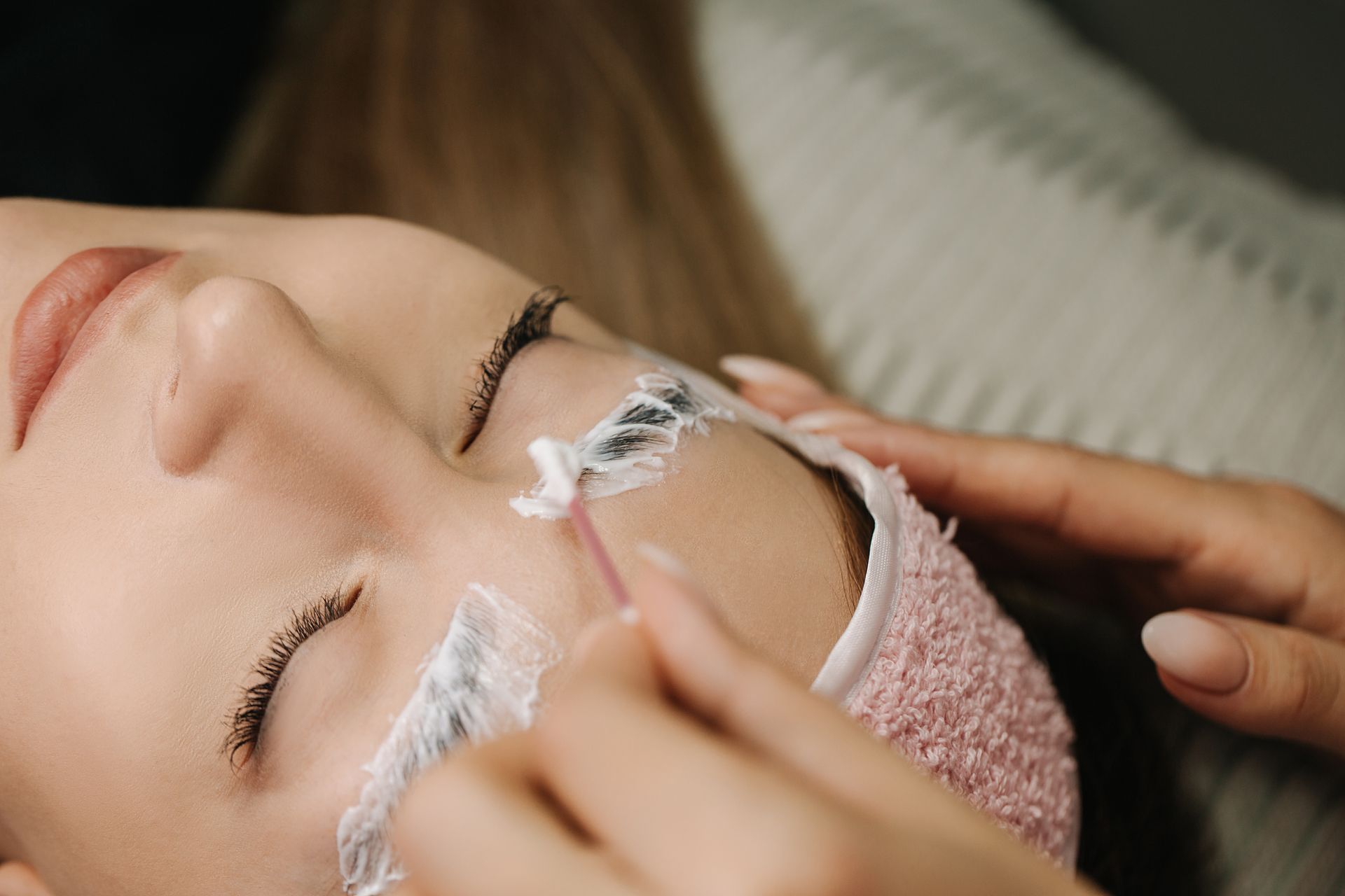 A woman is getting her eyelashes done at a beauty salon.